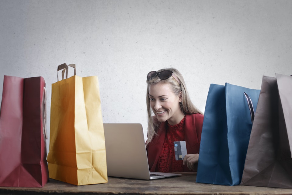 Mulher ao lado de sacolas comprando online